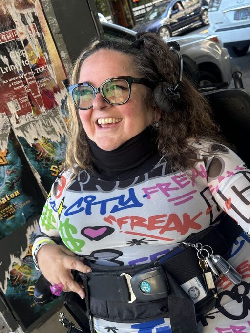 Nickole Cheron beams as she sports a colorful shirt on a bus.