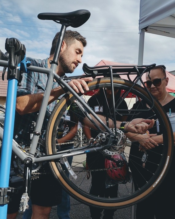 A bike mechanic fixes a flat at a pop-up clinic.