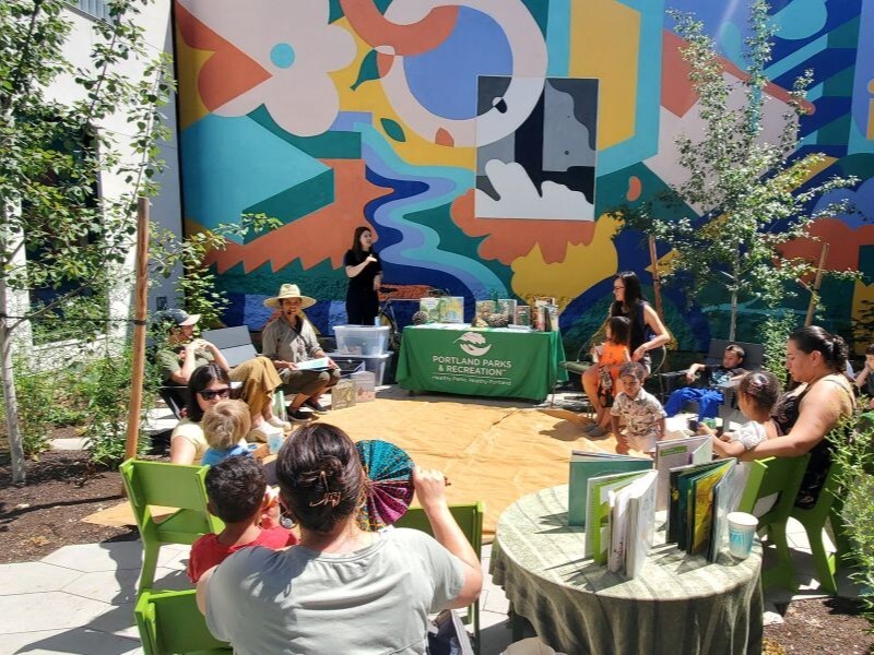 PPR - woman reading book to a group of young children and adults 