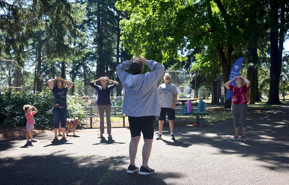 About six people participate in a group exercise class outdoors at a local park as part of Fitness in the Park and Summer Free for All