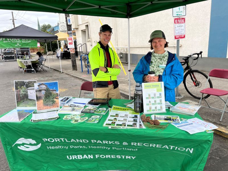 PPR- two people under green canopy behind table with outreach materials