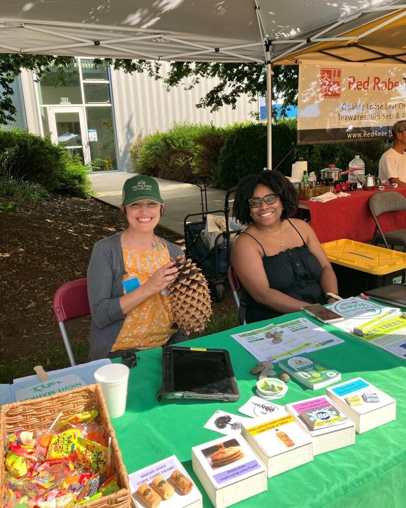 PPR - two women sitting at a table under a green tent