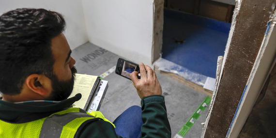 Residential building inspector using smartphone for inspection