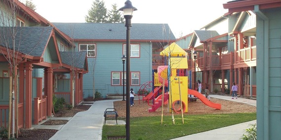 Newly built housing units surrounding courtyard with play structure