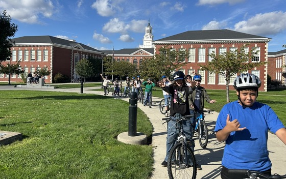 About 11 middle school students line up their bikes on a path on the Franklin High School campus.