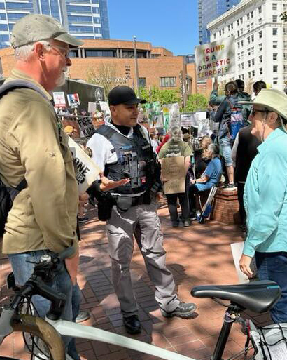 Dialogue liaison officer speaks with two people at Pioneer Courthouse Square