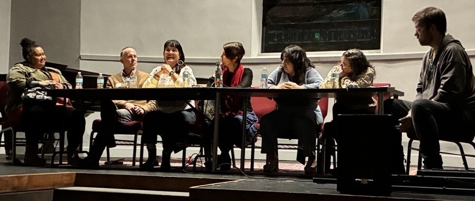 Group of people sitting at table on a stage