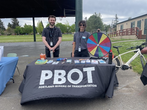 Two adults representing Portland Bureau of Transportation table at an outreach event.