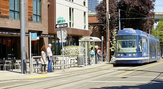 A street shows a bus and pedestrians for transportation system development charges story