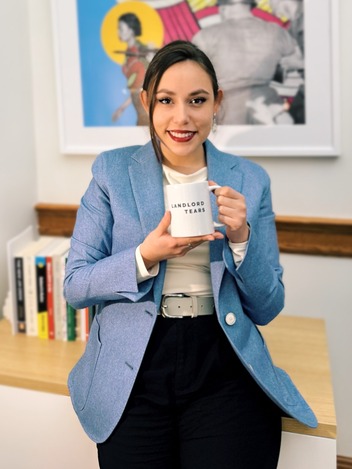 Councilor Morillo holding a mug that says "landlord tears"