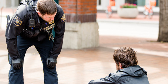 Police officer checks in on unsheltered neighbor in Pioneer Courthouse Square.