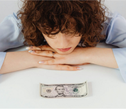Stock photo of person looking sad looking at a bill - financial hardship - financial distress