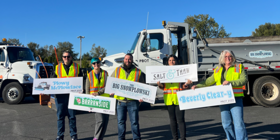 PBOT staff holding signs of last year's snowplow name winners