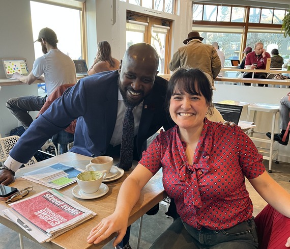 City Administrator Raymond C. Lee III and Councilor Koyama Lane at a table in a coffee shop, smiling at the camera
