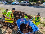 PPR - Children shoveling mulch into blue wheelbarrow
