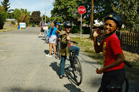Elementary school kids, students, smile at the camera while sitting on their bikes - bicycles