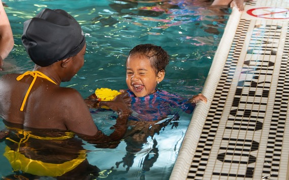 A child and parent enjoy an indoor swimming pool