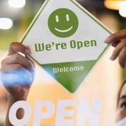 Green and white sign that says: open for business. 