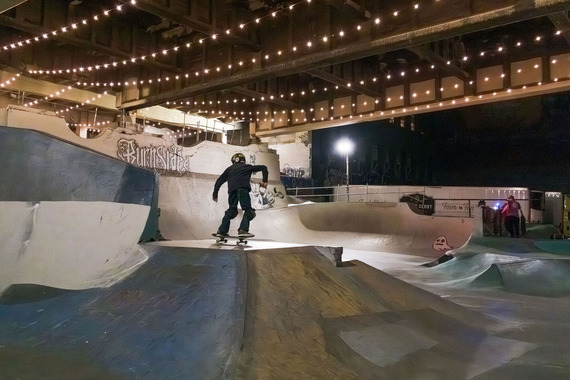 Lights are strung under the Burnside Bridge, illuminating the Burnside Skatepark at night. Public Environment Management Office project