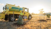 PPR - person plants tree in front of yellow truck with Cascadian written on the side 