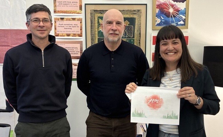 Policy Staffer Alan DeLaTorre, JASO Executive Director Graham Morris, and Councilor Tiffany Koyama Lane smiling at camera, holding JASO packet