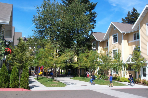 Townhouses surrounding treelined courtyard with children playing