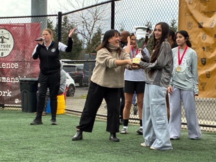 Councilor Koyama Lane awarding the winning team with a trophy