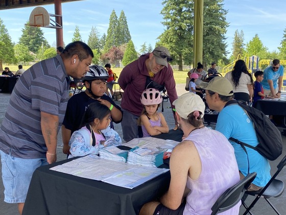 Individuals learning about route planning via bike during a bike fair in Portland's Northeast Cully neighborhood.