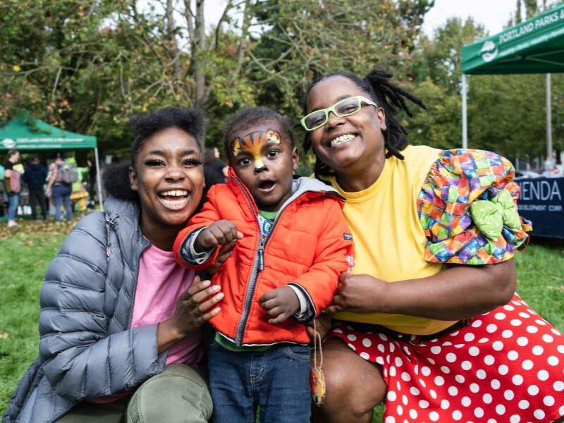 PPR - Two adults and a child with tiger face painting posing 