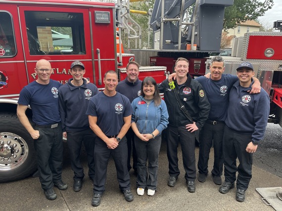 Councilor Koyama Lane with group of firefighters from Station 25 in Woodstock Neighborhood, smiling in front of red fire crane