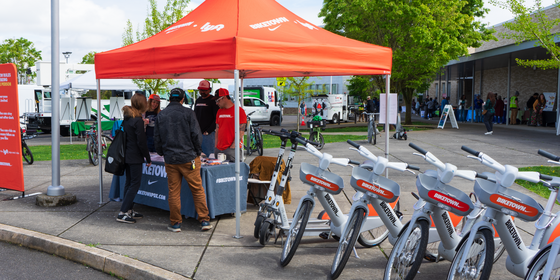 Gray Biketown Cosmo e-bikes lined up at Earth Day event in April 2026