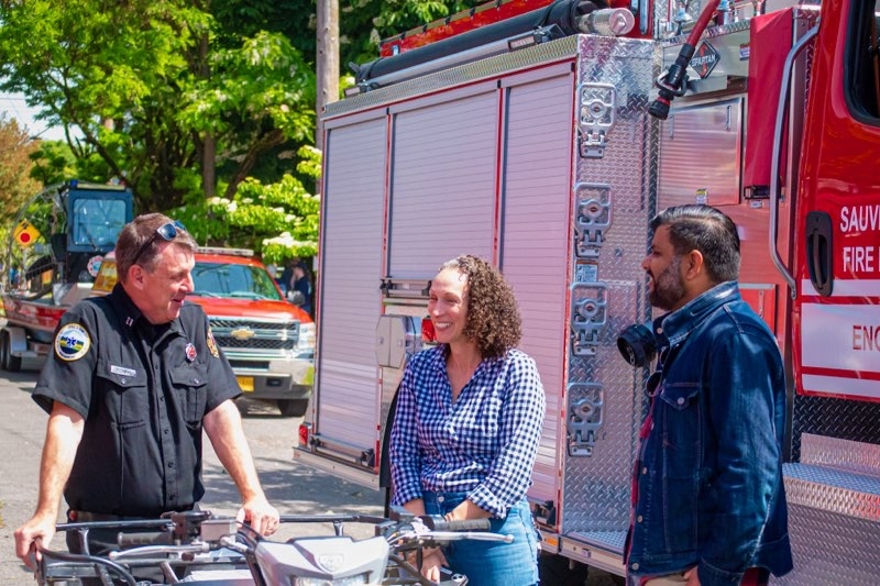 Councilor Pirtle-Guiney, Councilor Kanal, and a Station 22 employee smile and chat outside of a fire engine in St. Johns. 