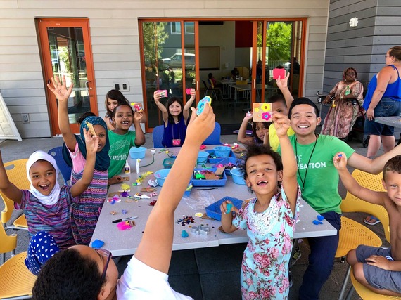 A table full of young people show off their art at a Portland Parks & Recreation Free Lunch + Play event in East Portland. 