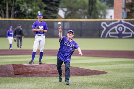 Councilor Ryan, wearing a purple University of Portland jersey, on the pitcher's mound at Joe Etzel Field after throwing out the game's first pitch.