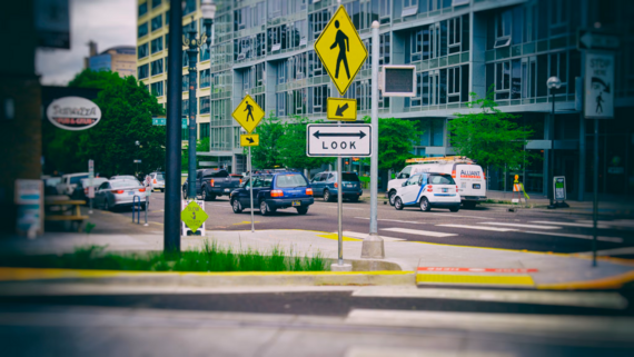 bioswale with pedestrian crossing and apartment building in background