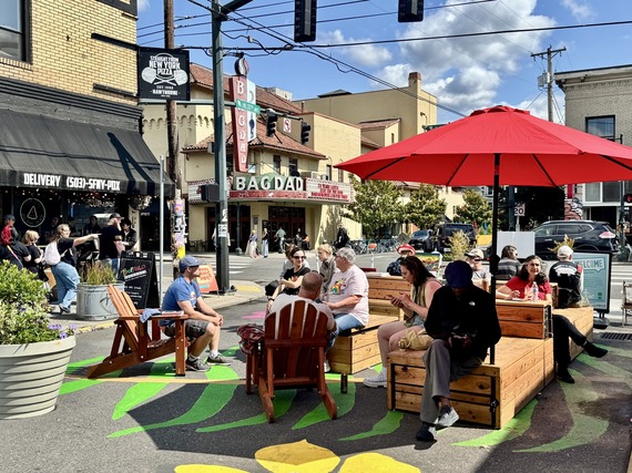ARTS - Hawthorne grand opening event with people in an open street area on multiple chair types with painted asphalt below.