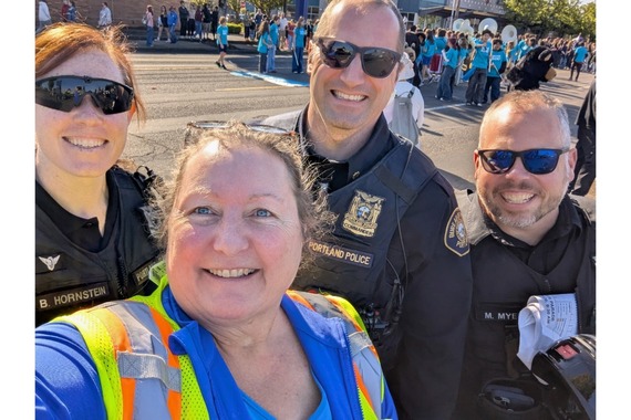 Allison Madsen is PBOT's special events coordinator. She takes a selfie with police officers at a parade.