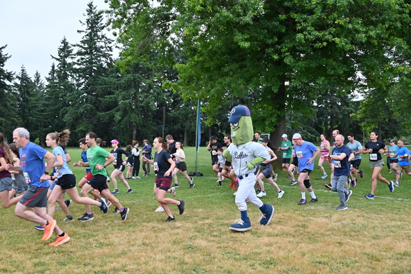 group of 5K runners run at Lents park with Dillon the Pickle.