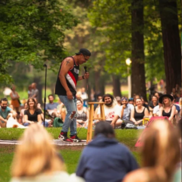 Kickstand Comedy in the Park - a comedian stands in front of a crowd outdoors