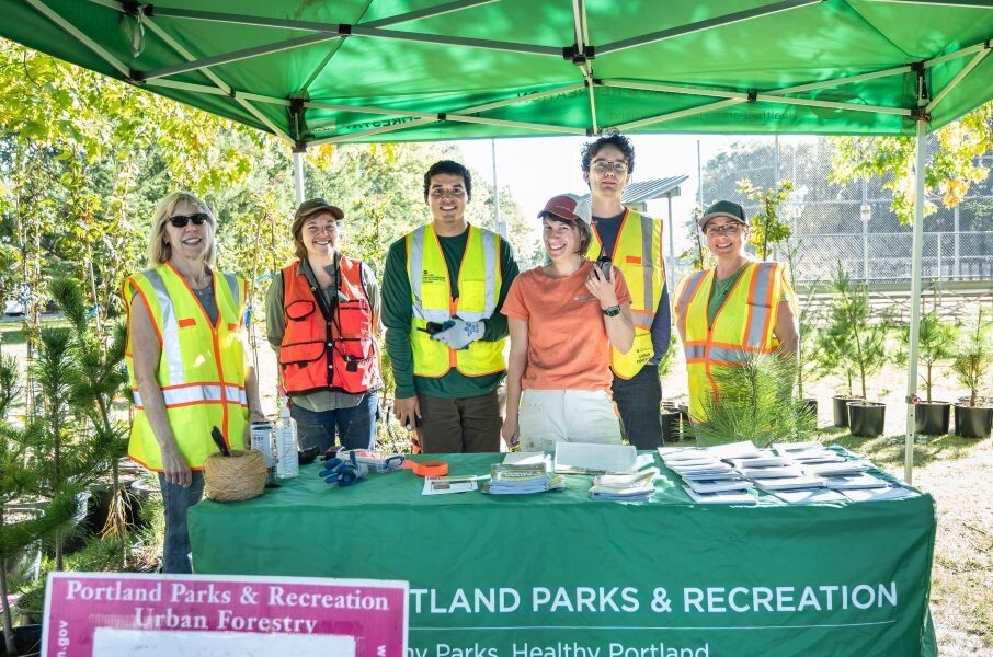PPR _ Group of people standing under green tent behind green table