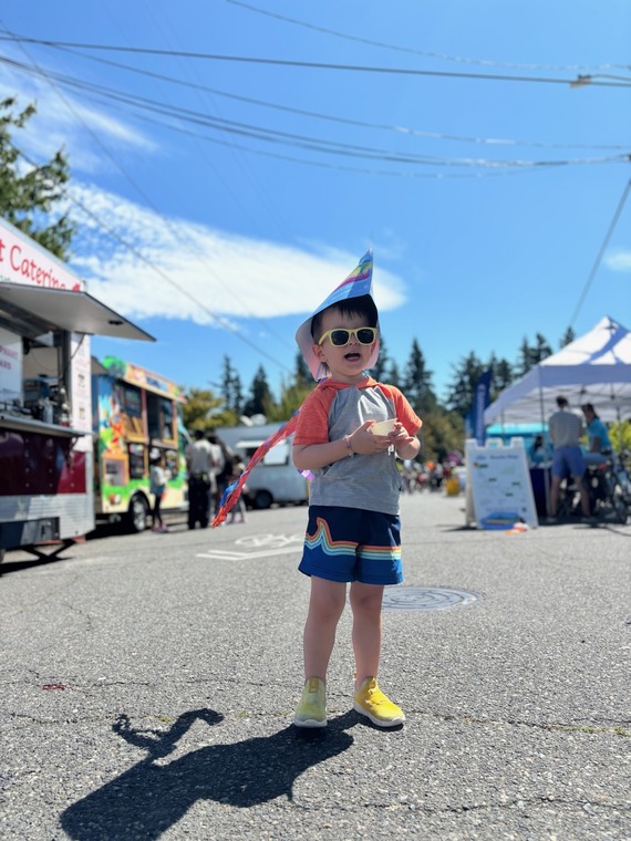 Sunday Parkways photo shows a small child wearing a salmon hat with tents and tables in the background