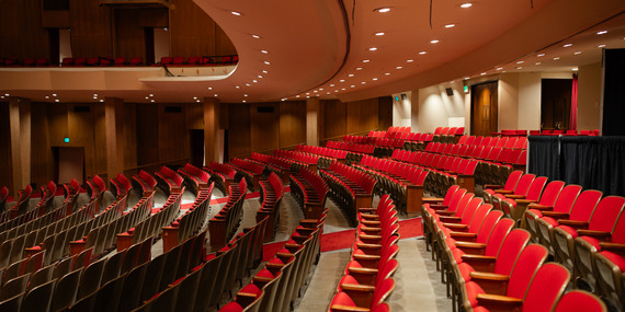 ARTS - Rows of empty red chairs with dramatic lighting, showcasing the seating inside Keller Auditorium.