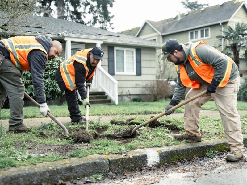 Three men digging a hole