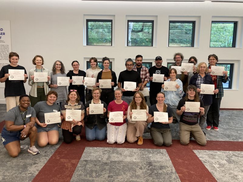 Group of people holding graduation certificates from NTS program