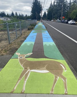 Sidewalk mural shows deer and trees.