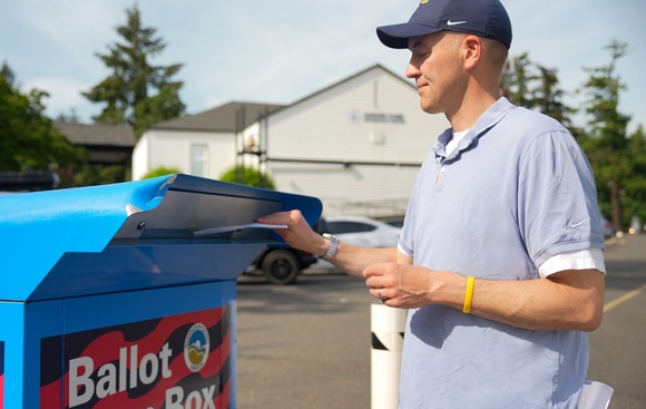 Secretary Read returning his ballot to an official ballot drop box.
