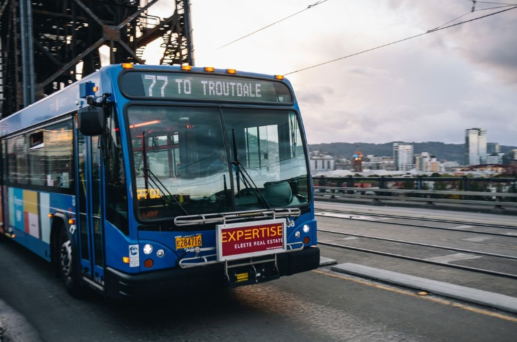 Bus line 77 moving east towards the Rose Quarter transit center, with clouds hanging over the Pearl District in the background