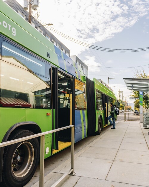 FX bus stopped on Division at station with rider boarding