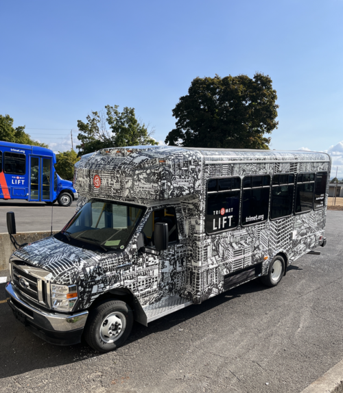 A LIFT vehicle wrapped with art of the Portland cityscape