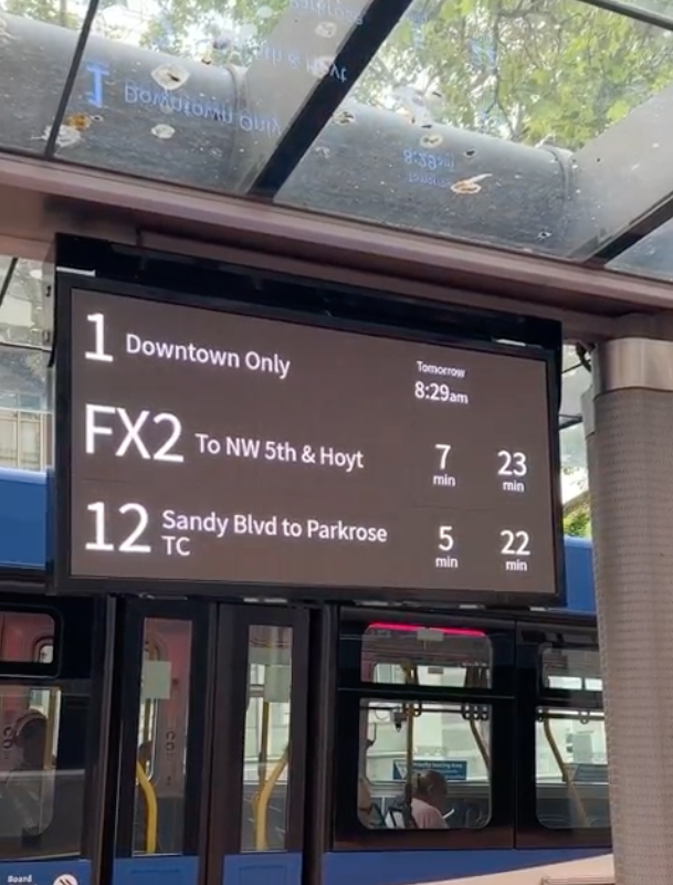 A screen at a bus stop that displays arrival times